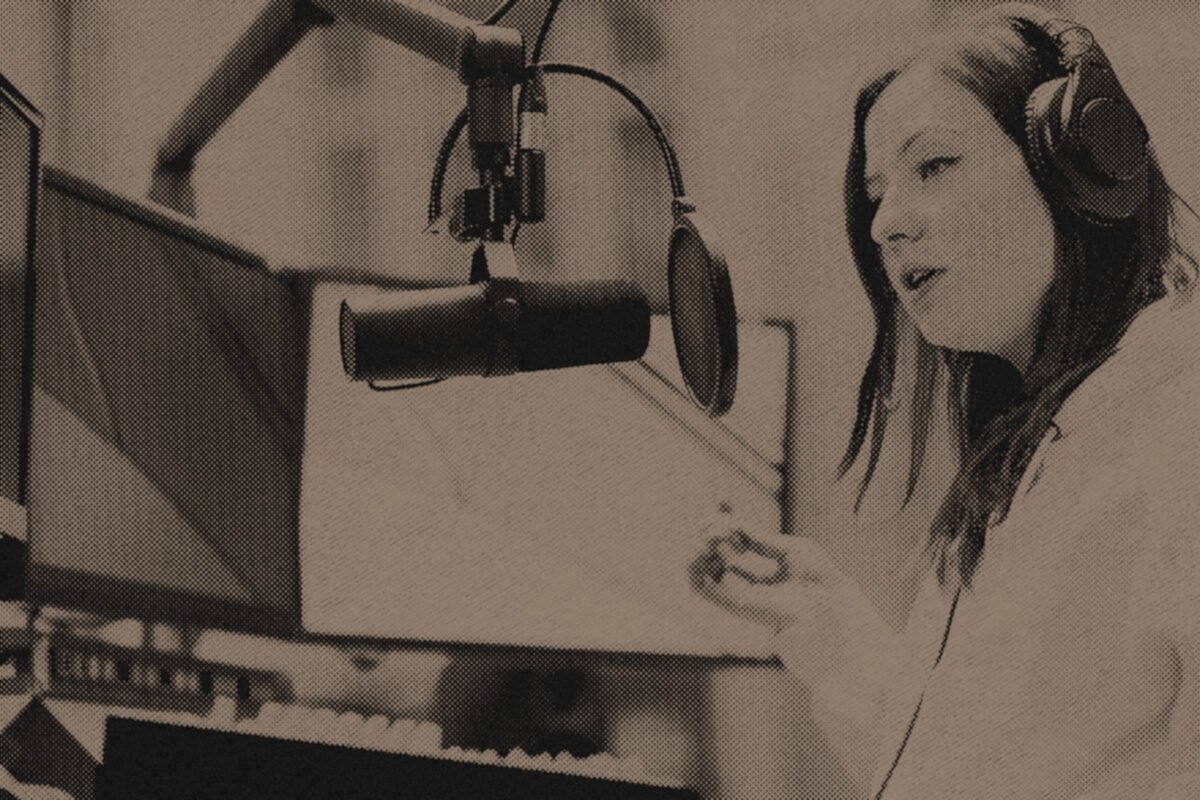 A podcaster recording at a studio microphone